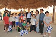 President Shimon Peres poses with the elementary school aged children of Kibbutz Lotan and education staff at the entrance to the Center for Creative Ecology's EcoPark