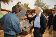 Kibbutz General Director Mark Naveh, a NETZER graduate from Australia, boils water for tea with President Shimon Peres in one of Kibbutz Lotan's solar ovens &ndash; an environmentally friendly way to save electricity.